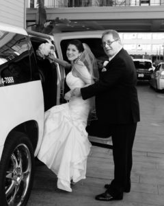 Dad helping the bride into the limo