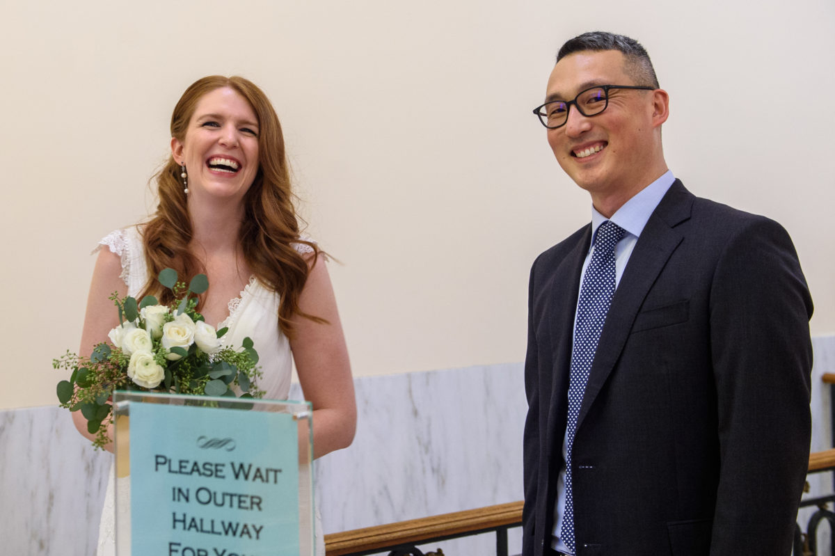 Candid shot of the couple checking in for their city hall wedding in San Francisco, CA