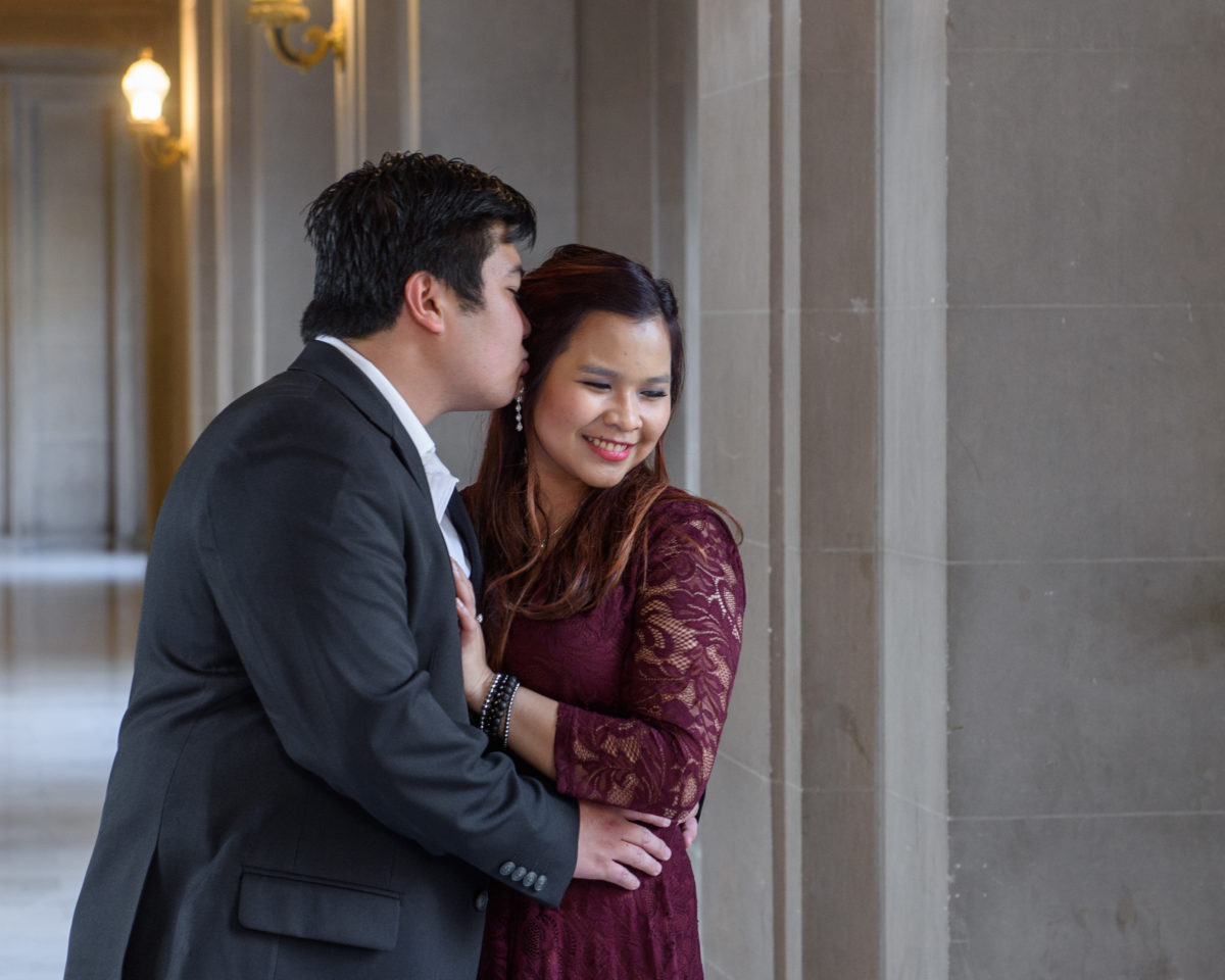 Groom kissing bride on the 3rd floor of SF City Hall