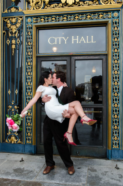 San Francisco city hall wedding picture at the front entrance - groom kissing bride