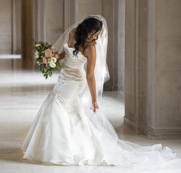 San Francisco city hall bride adjusts her wedding dress
