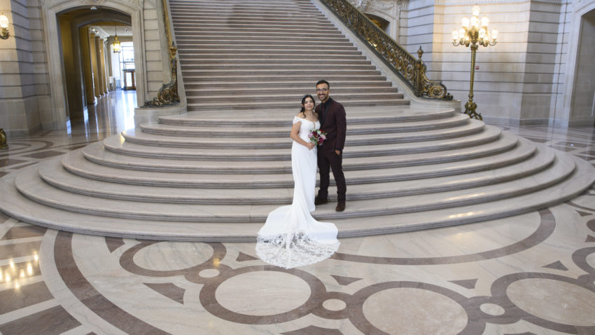 Bride and groom posing on the Grand Staircase at beautiful San Francisco city hall