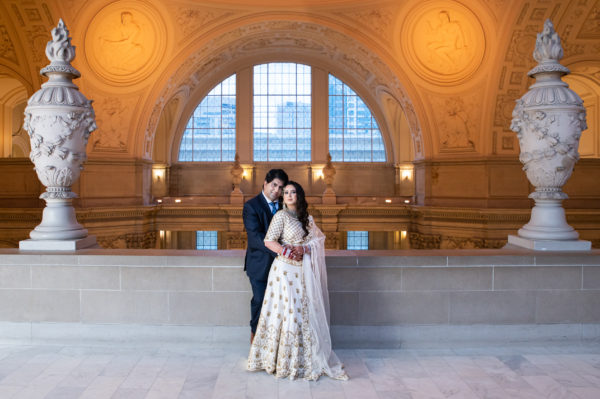 Indian bride and groom posing on the 4th floor of city hall in San Francisco