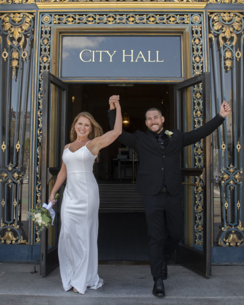 Newlyweds celebrating recent nuptials as they exit San Francisco city hall