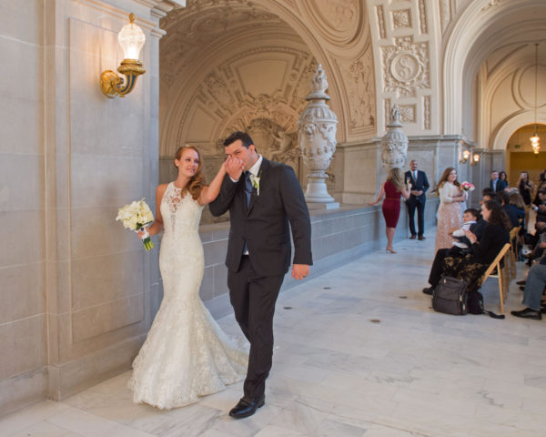 Happy couple walks off after the completion of their reserved city hall wedding.