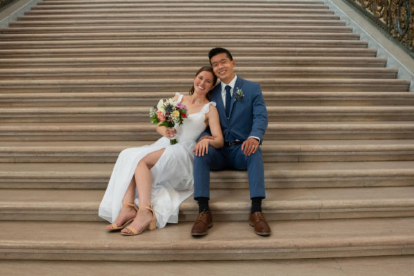 City Hall newlyweds sitting on the Grand Staircase