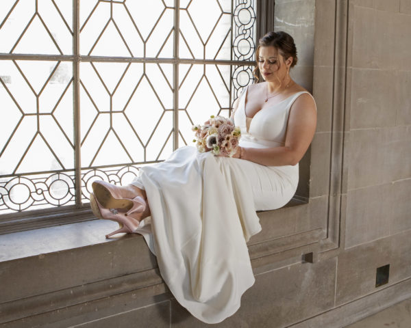 Bride Sitting on Window sill at San Francisco city hall