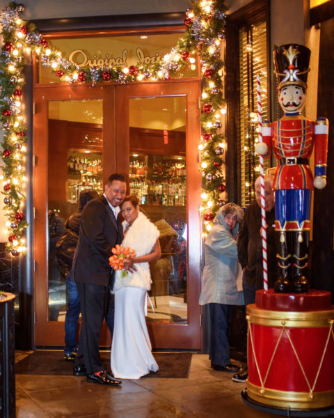 Newlyweds sheltering from the Rain before entering Restaurant in San Francisco.