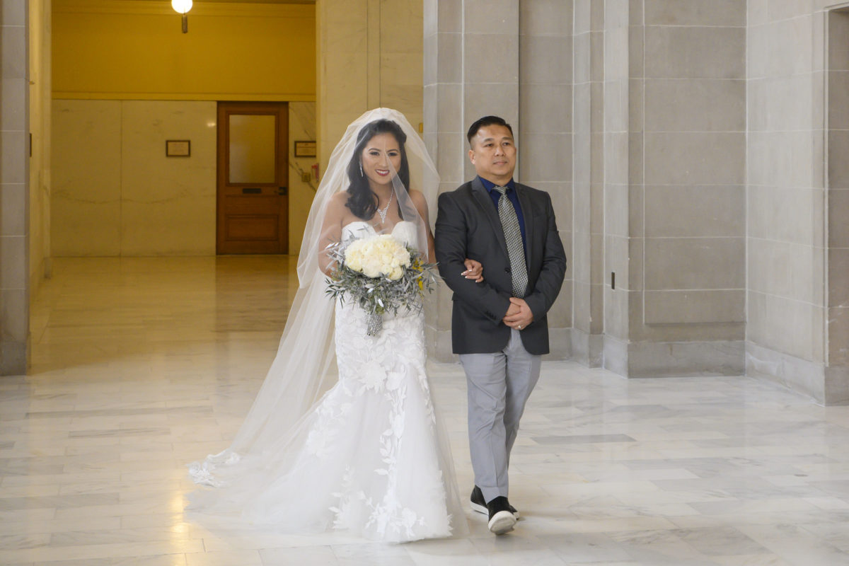 Bride walking in to a reserved wedding at San Francisco city hall.