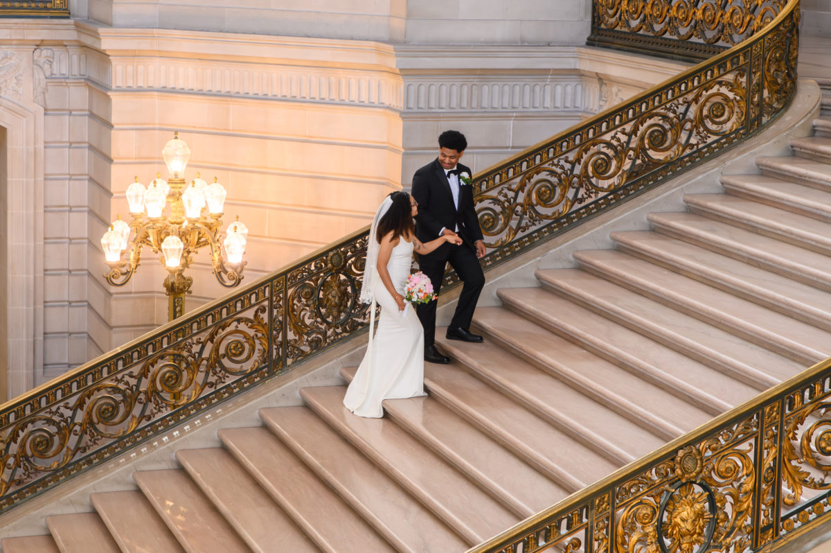 SF city hall newlyweds walking up the Grand staircase.