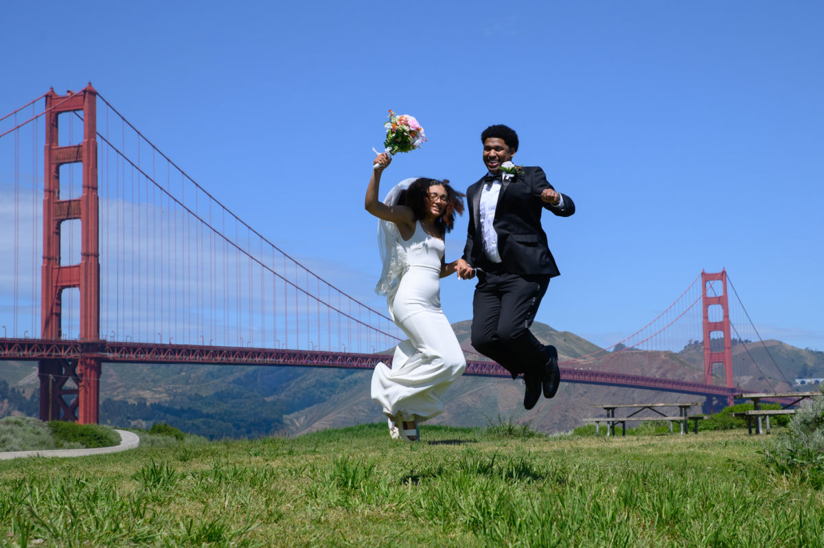 San Francisco city hall bride and groom jumping in front of the Golden Gate Bridge
