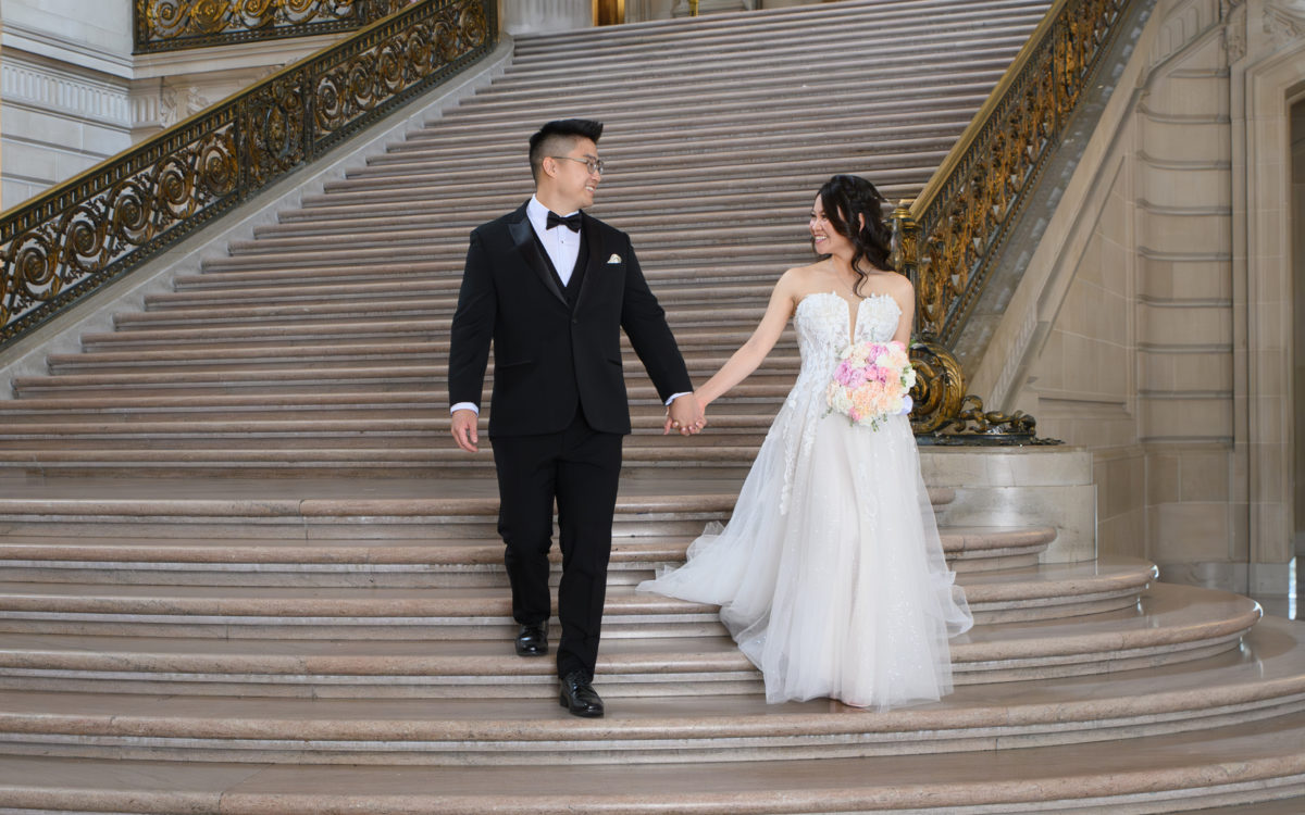 San Francisco city hall wedding couple walking down the Grand Staircase after their marriage.