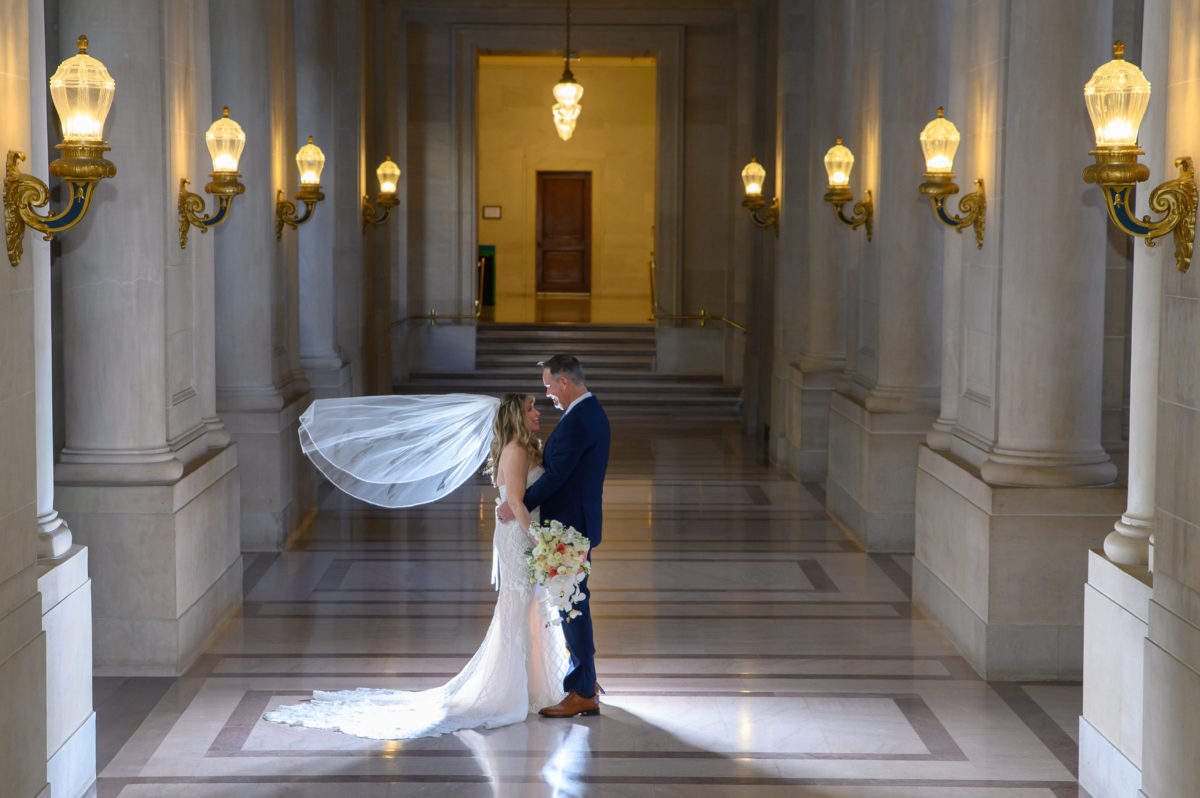 San Francisco city hall wedding picture with veil blowing in air