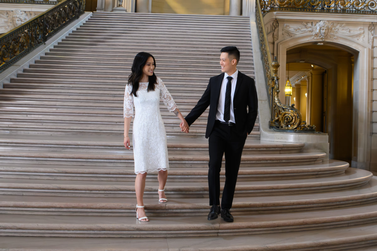 San Francisco city hall newlyweds walking down the Grand Staircase after their wedding ceremony