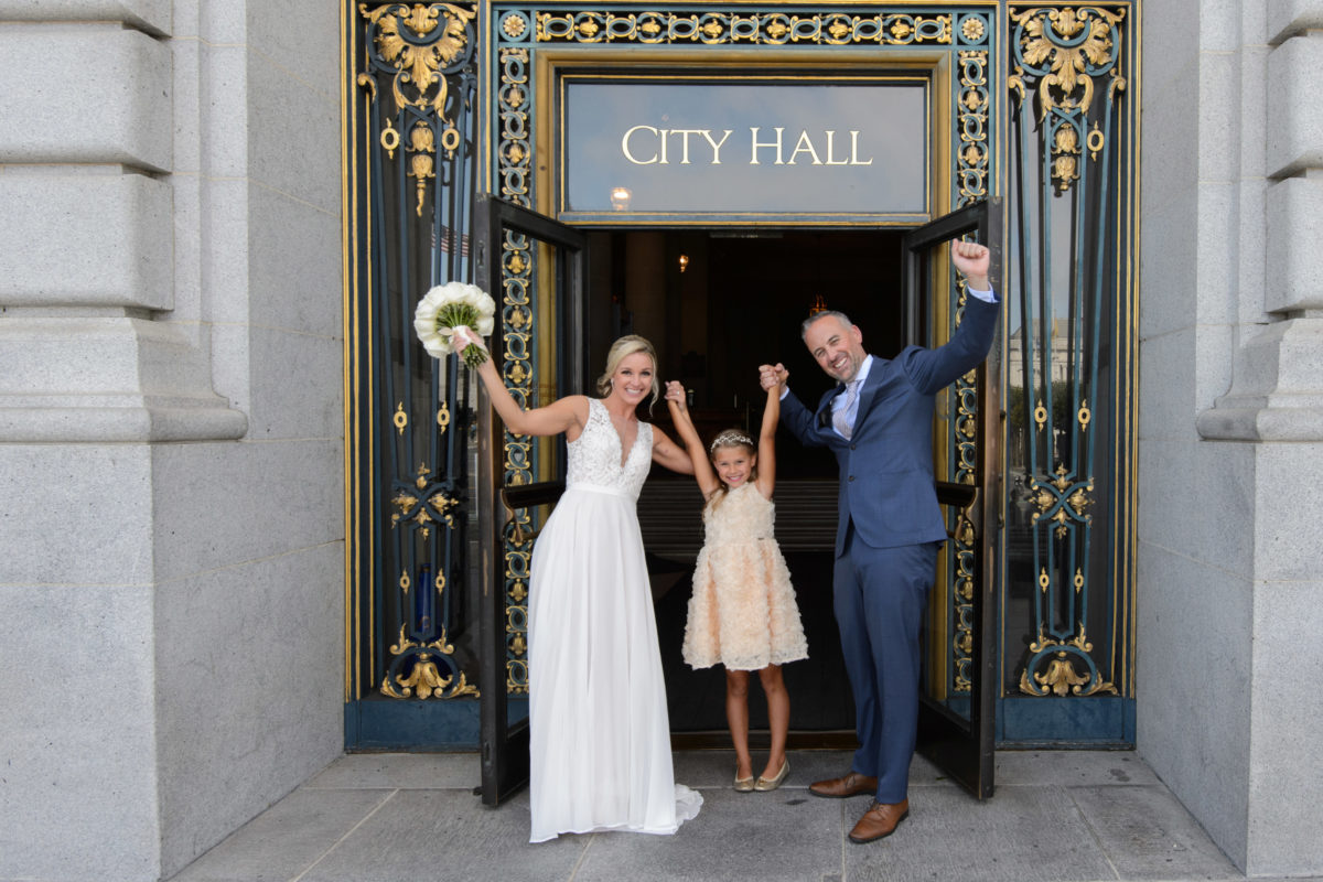 newlyweds celebrating their San Francisco city hall wedding with their daughter
