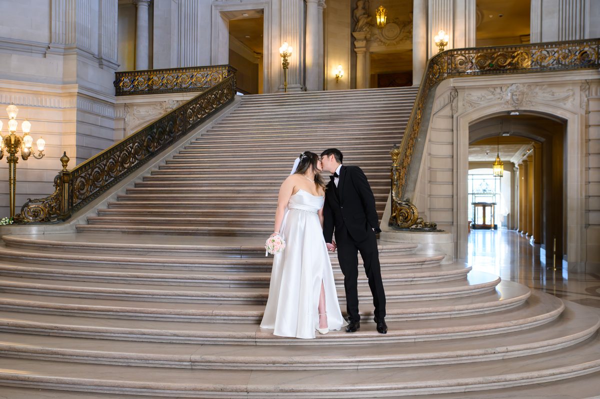 City Hall Bride and Groom kissing on the Grand Staircase after wedding