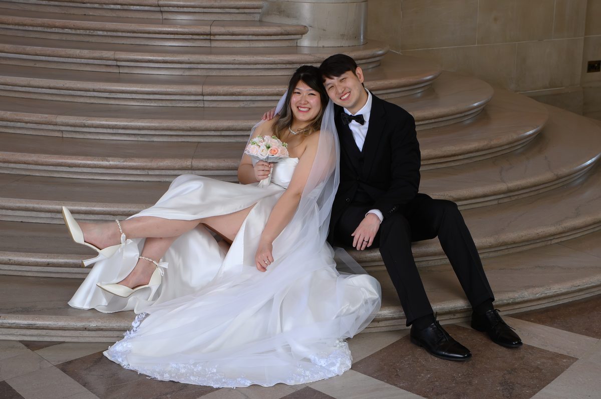 Bride displaying her flowers on the Grand Staircase at SF city hall